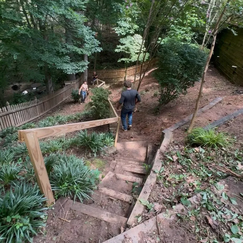 The same hillside steps after clearing, with the handrail and timber treads visible again
