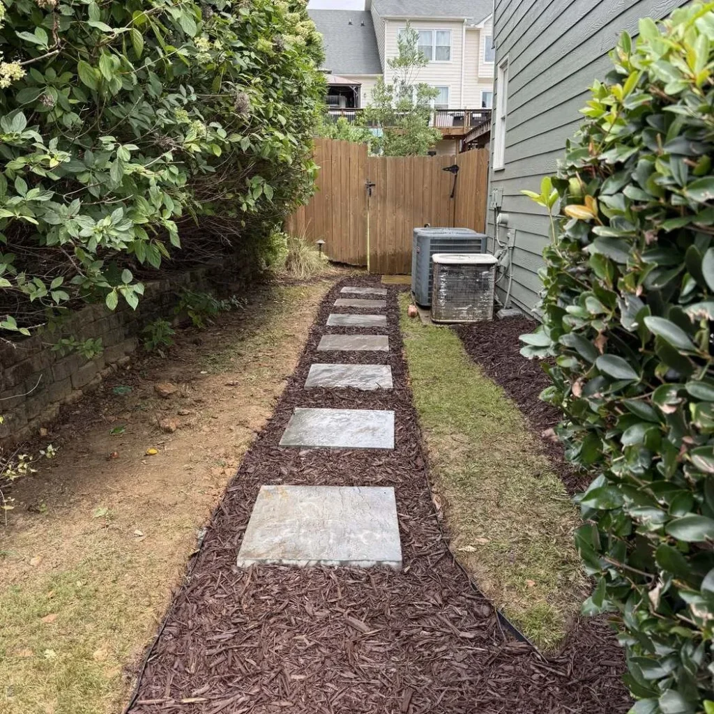 The same narrow side yard after stepping stones and a mulched border were installed